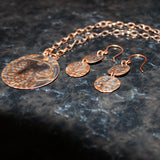 handcrafted embossed round wisteria patinaed copper pendant on chain with matching earrings