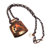textured copper pendant with black seed beads on copper chain